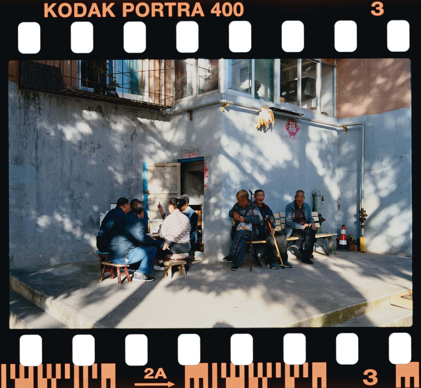 Neighbours in a sunlit courtyard, Kodak Portra 400 on 135, printed on Kodak Supra Endura.